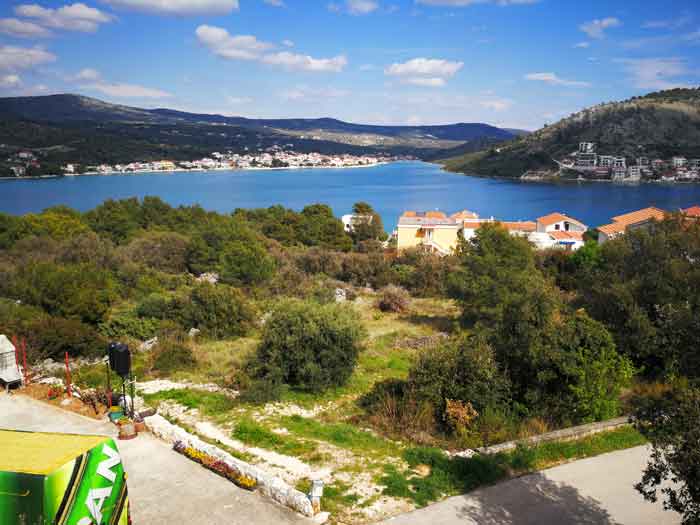 View of the bay and coastal town, with Mediterranean vegetation in the foreground