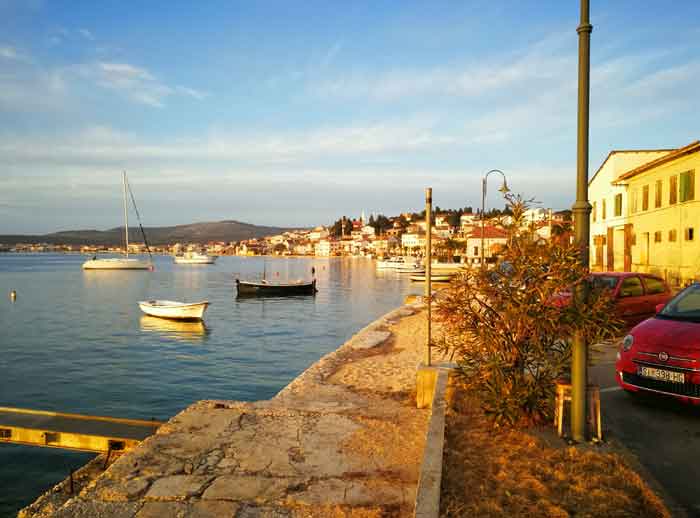 Rogoznica harbour promenade in the evening light with boats on the water